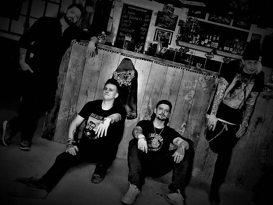 Black and white photo of the band in front of a non-descript wall