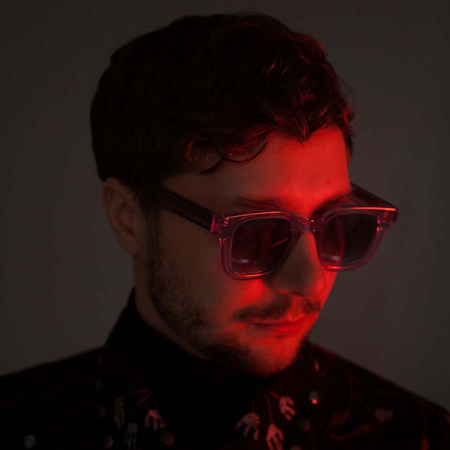 Headshot of a man wearing sunglasses with a red overlay