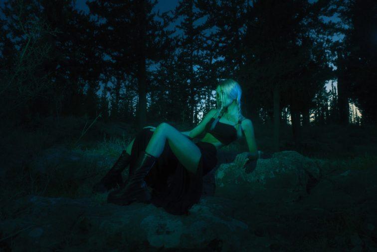 woman laying on the ground in the woods at night