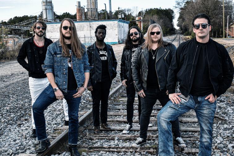 6 band menbers standing on railroad tracks