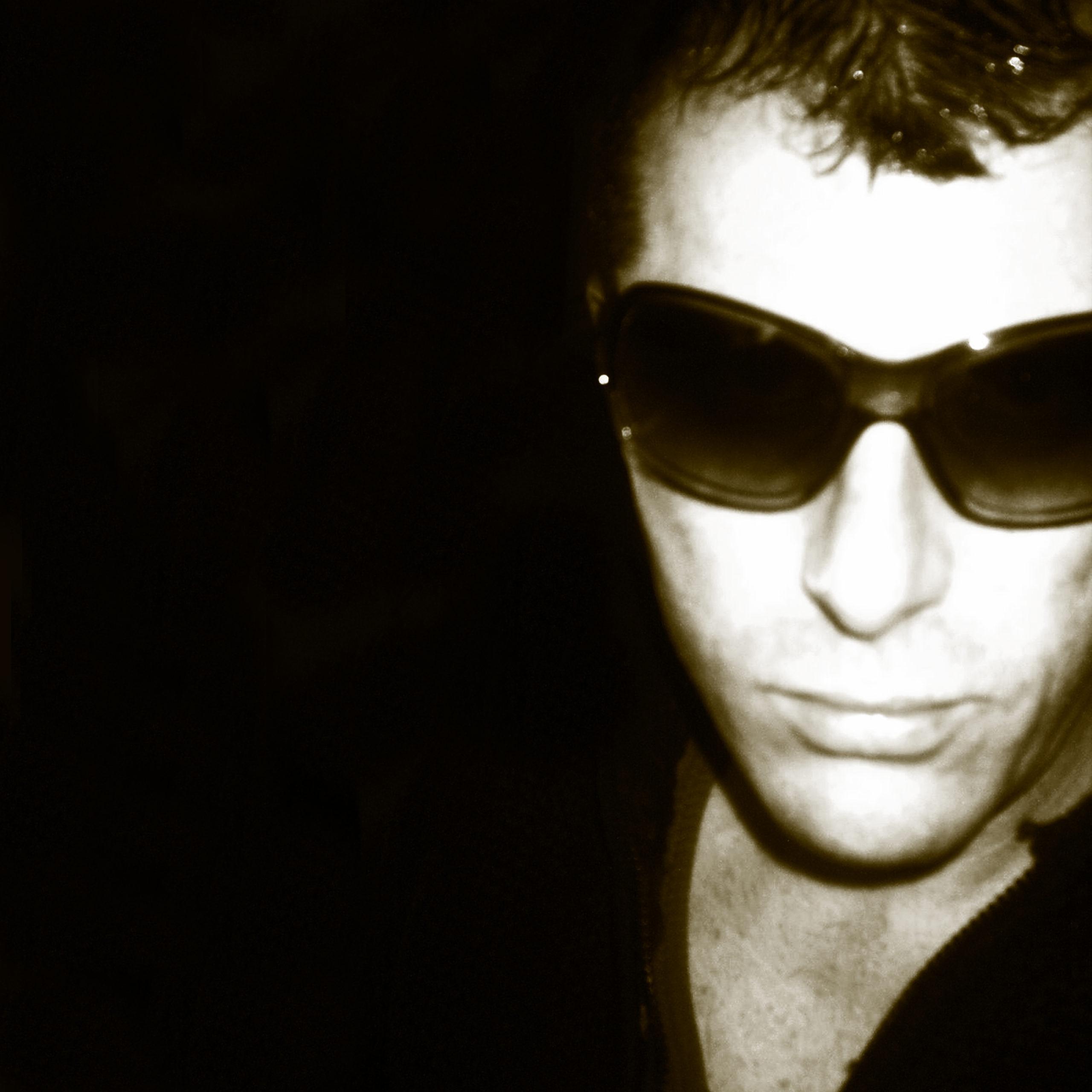 black and white headshot of a man wearing sunglasses