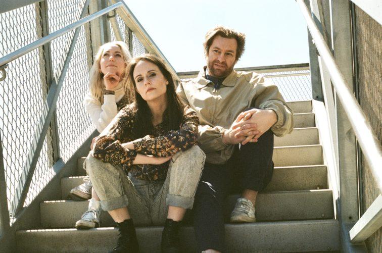 three peopel sitting on stairs outside