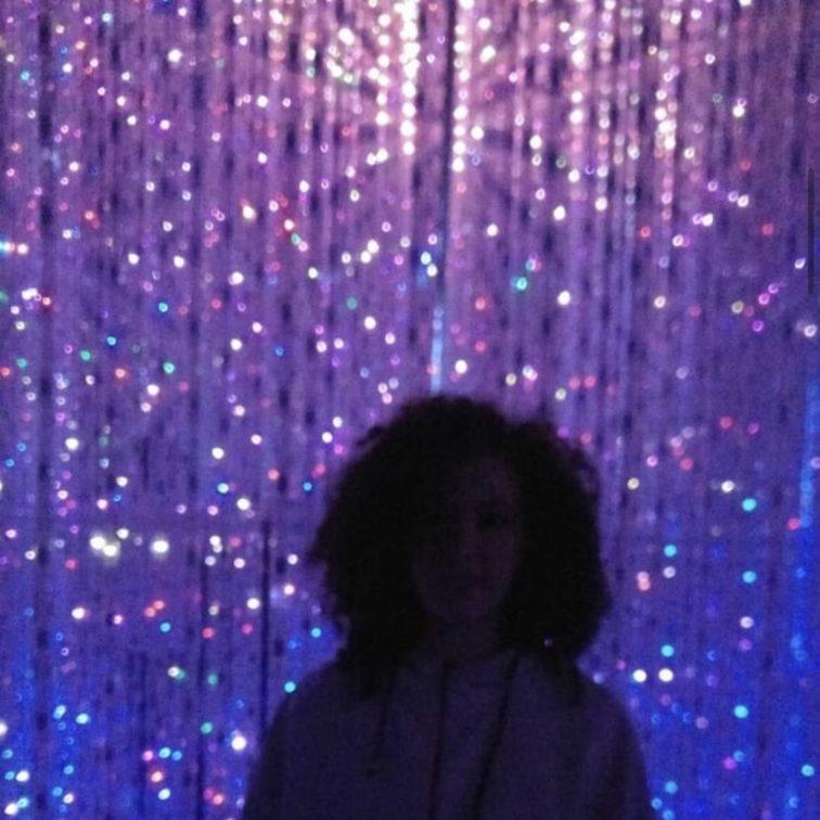 woman standing in front of purple curtain on stage