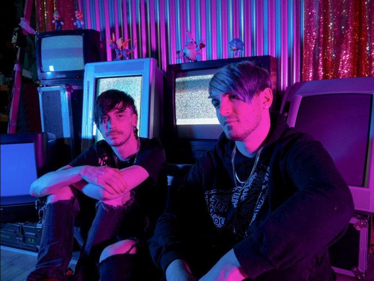 2 band members sitting in front of computers