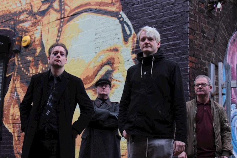 band members standing outside in front of a brick wall