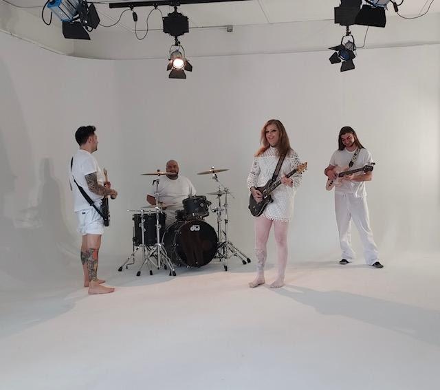 band playing instruments in an empty white room
