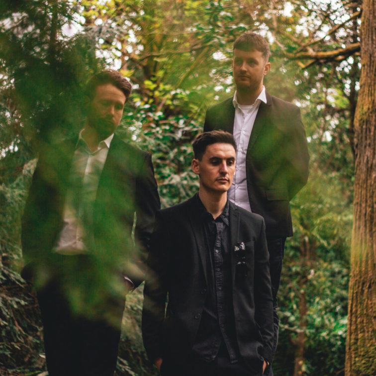 3 band members standing in the woods