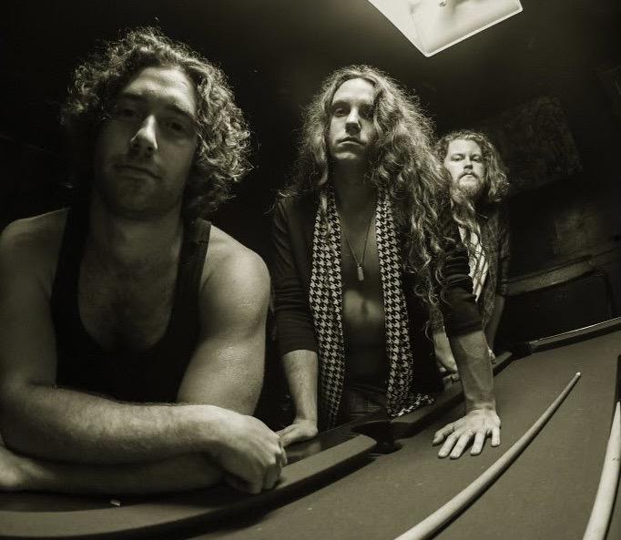 band members leaning on a pool table