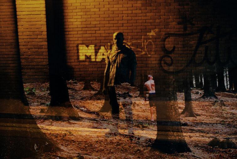 man standing in a alley at night