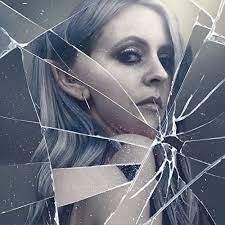 woman looking through broken glass