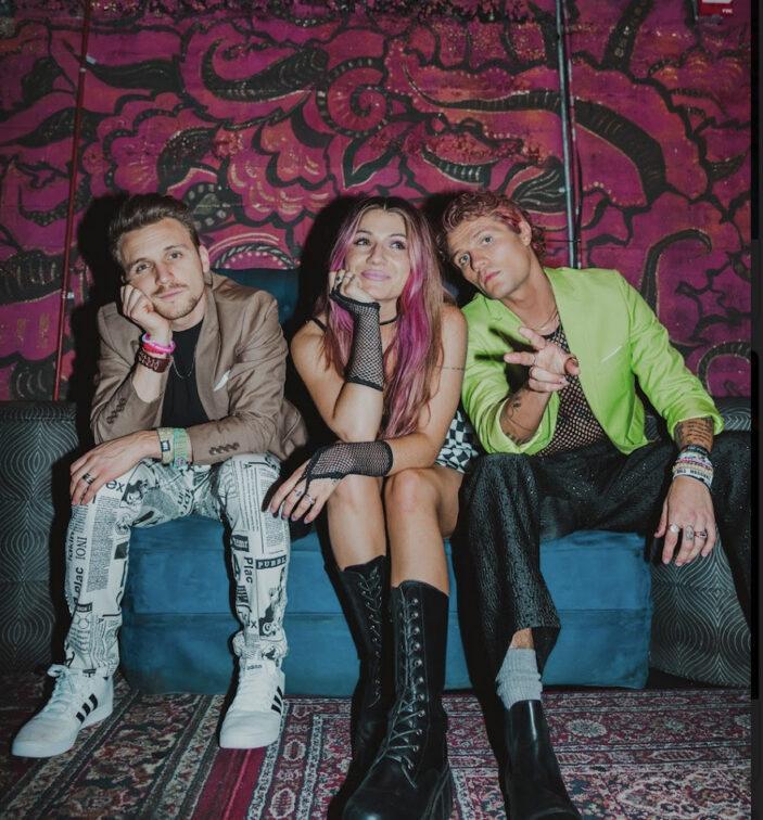 two guys and a girl sitting on a blue couch
