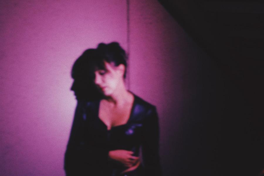 woman standing in front of a purple wall