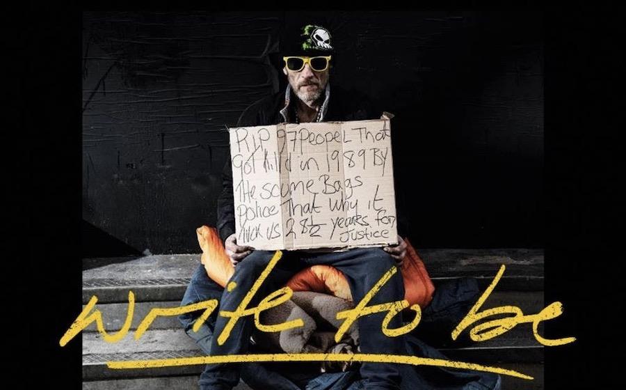man sitting in steps holding a sign
