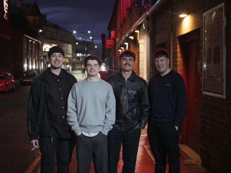 4 men standing in the street at night