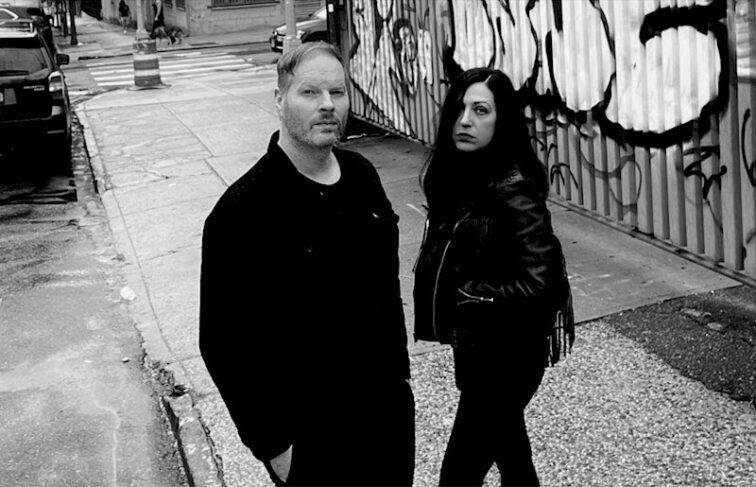 man and woman standing on a sidewalk