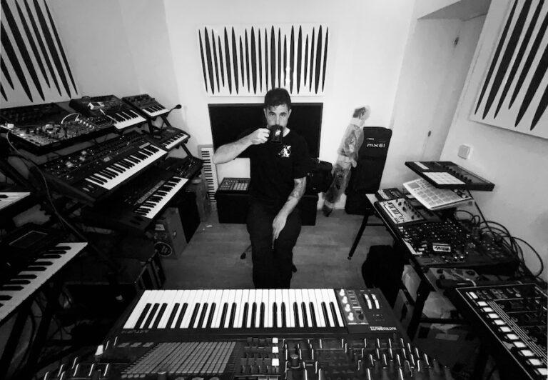 man in a studio surrounded by pianos and keyboards