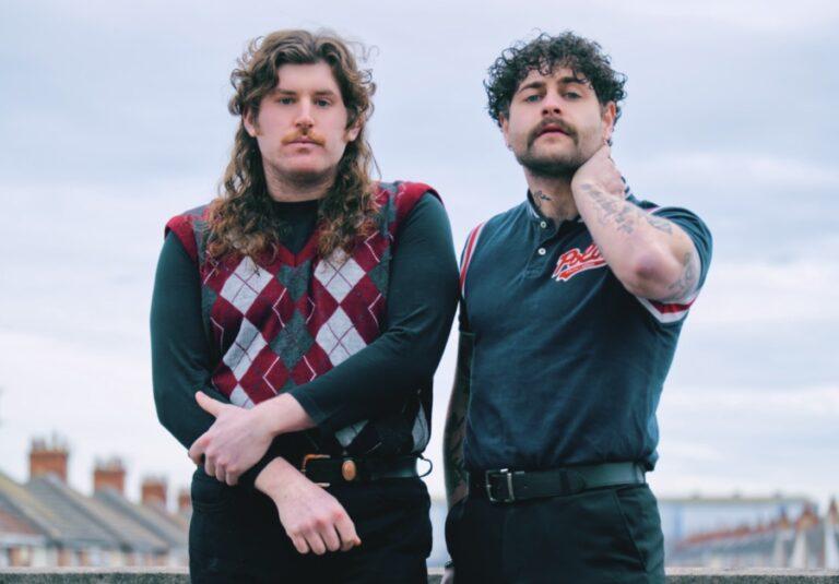 two an standing next to each other outside