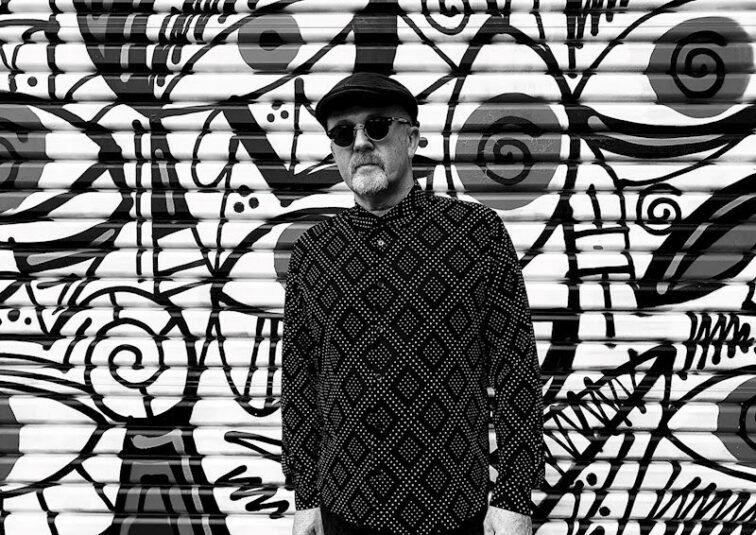 man standing in front of a black and white wall