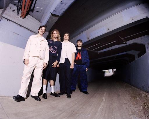 4 band members standing under a bridge