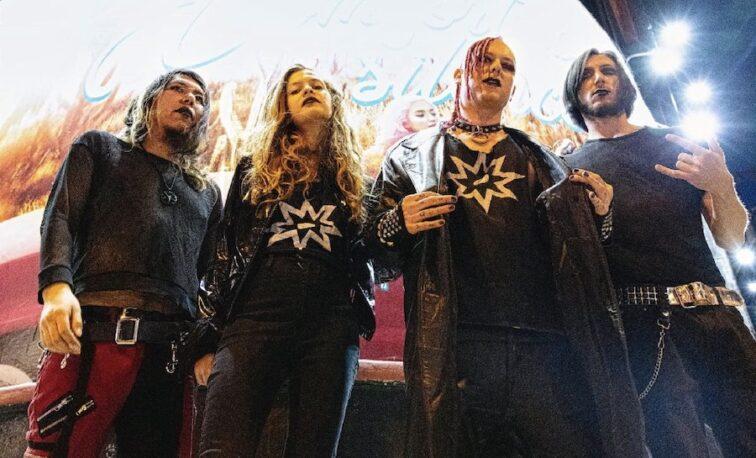 goth metal band standing outside a theater