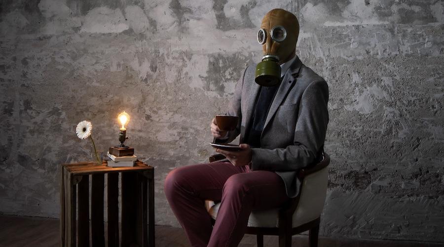 man sitting in a chair wearing a gas mask