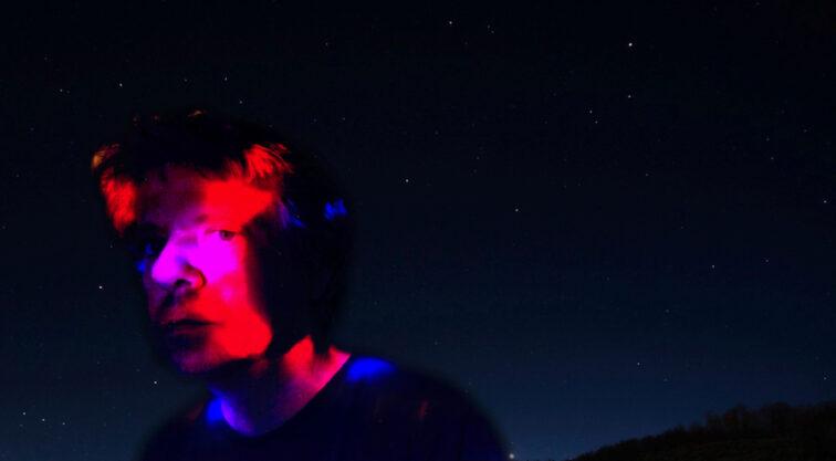 a man's face with star-filled night sky in the background