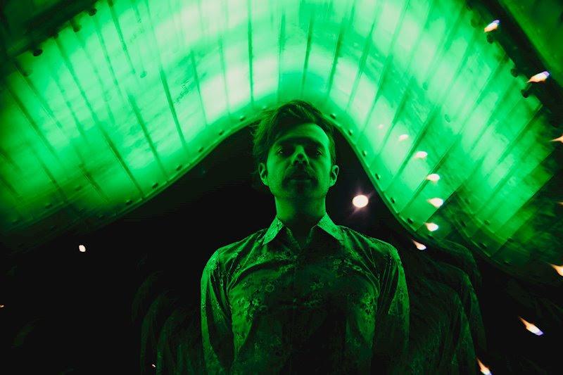 man standing under neon green lights