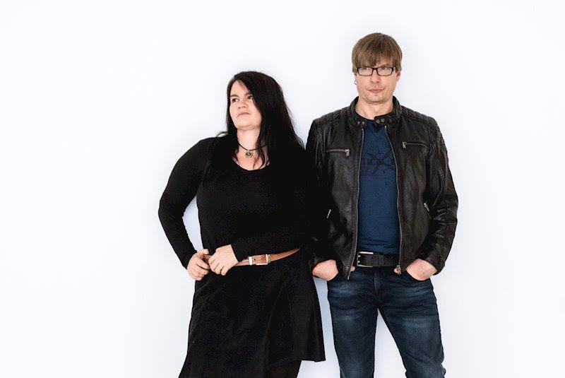 man and woman standing in front of a blank white wall