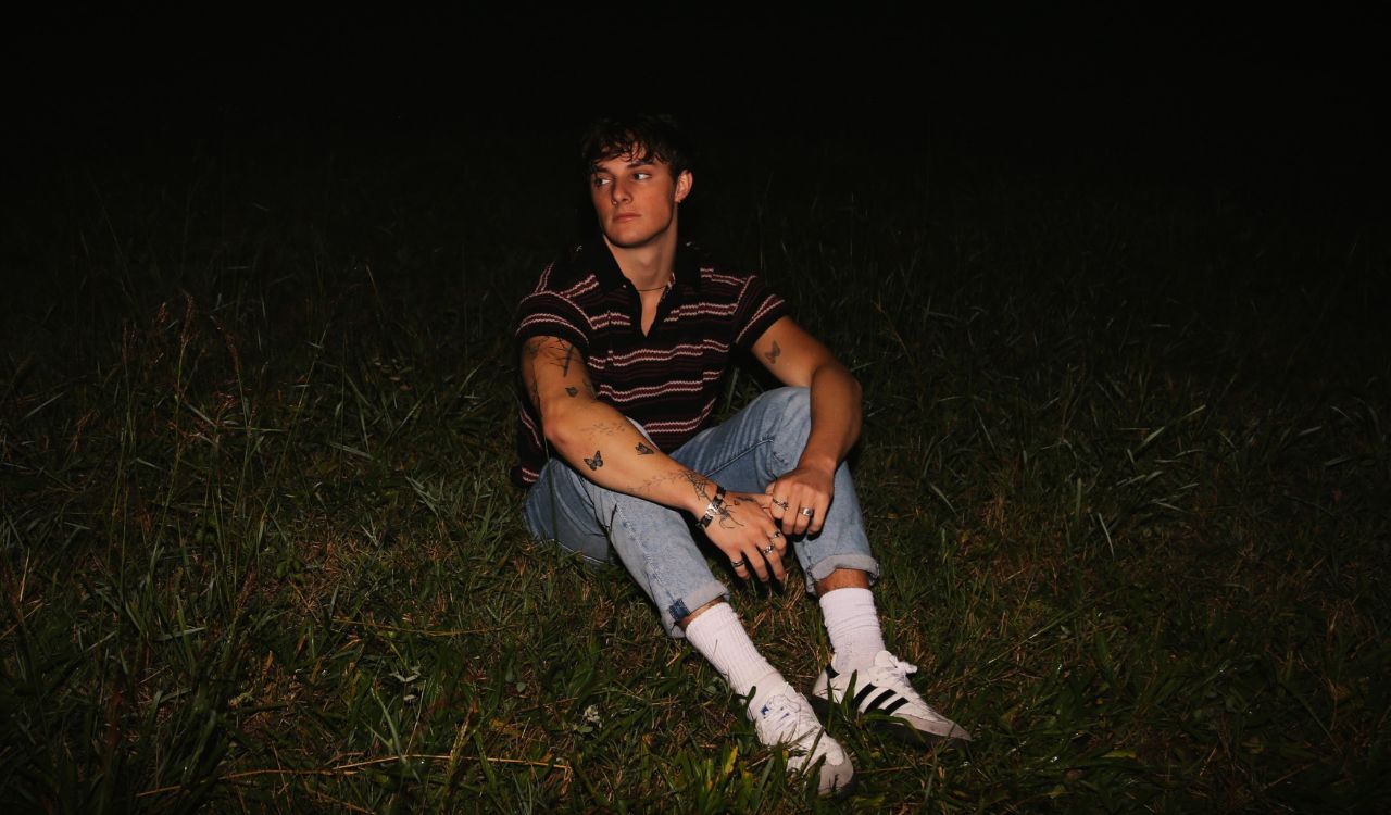 man sitting in the grass at night