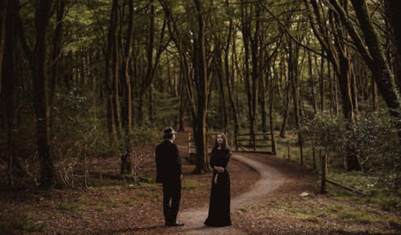 man and woman standing in the woods