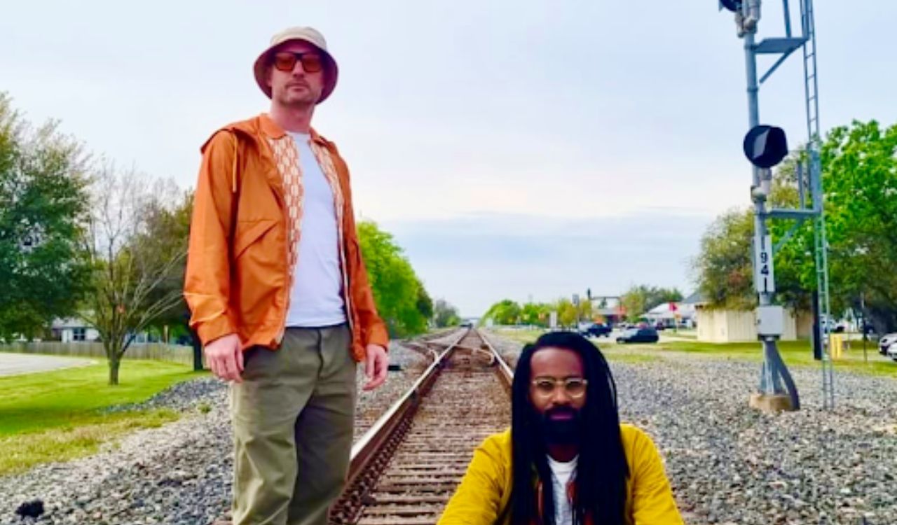 two men standing on railroad tracks