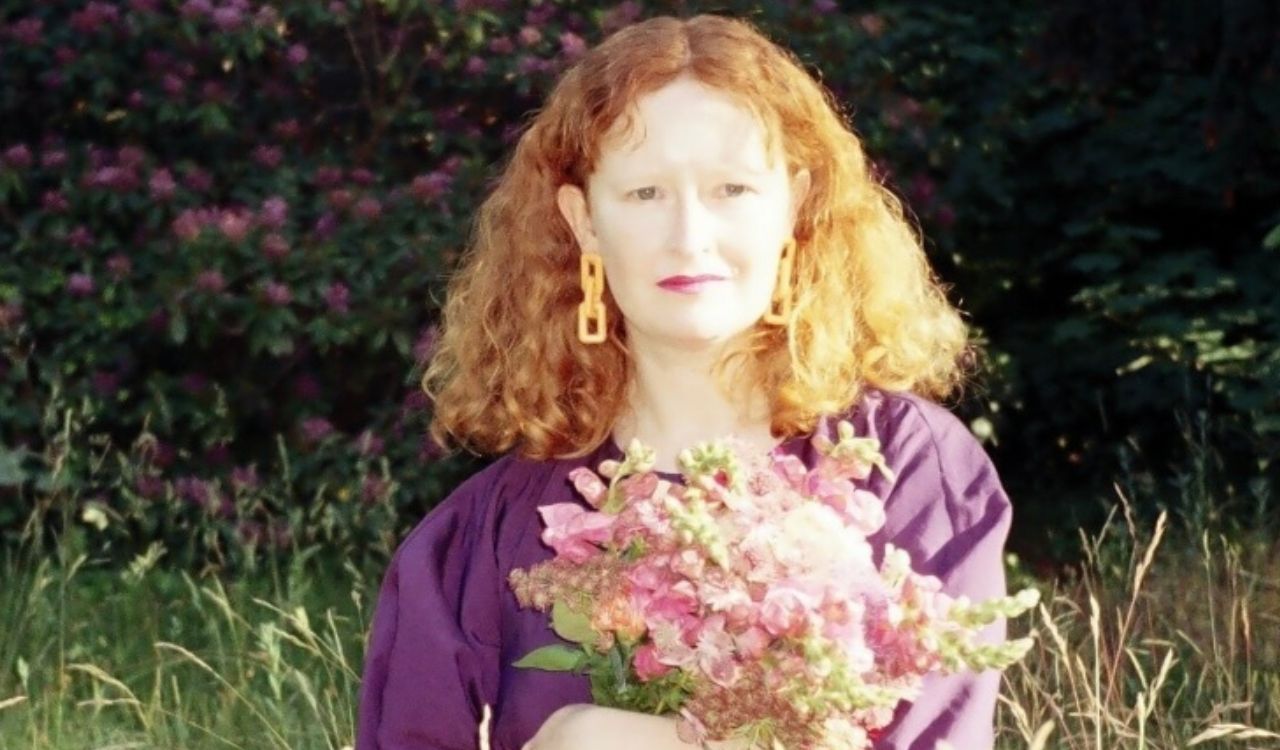 woman sitting in a field holding flowers