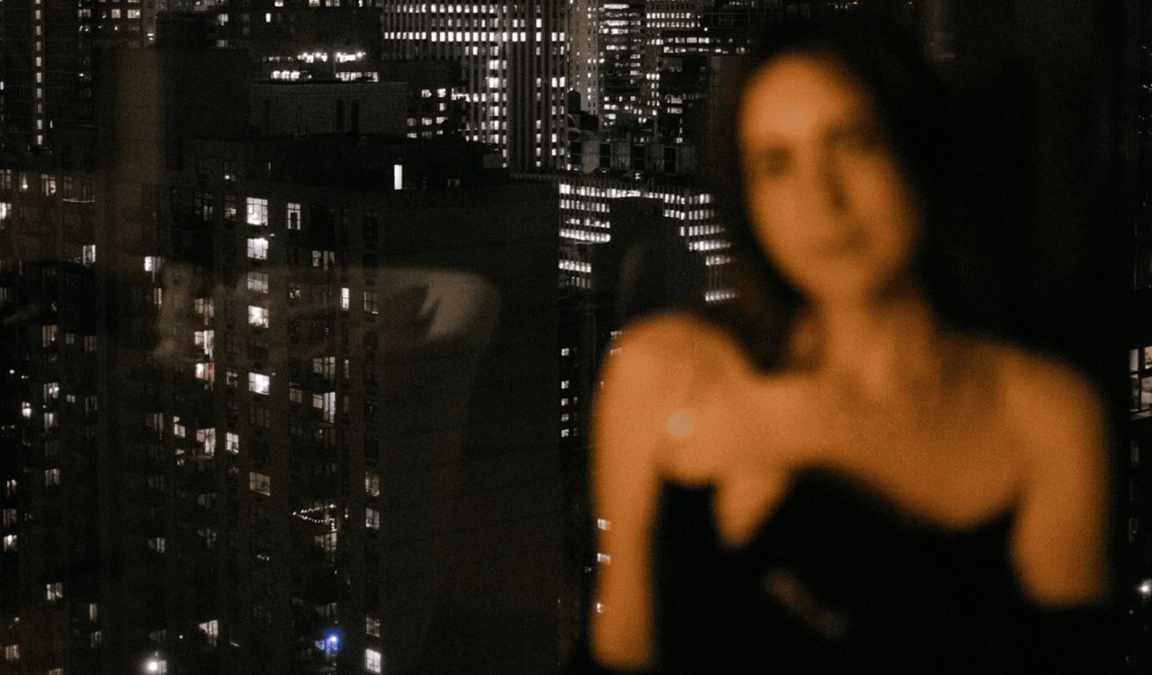 woman in front of a city-scape at night