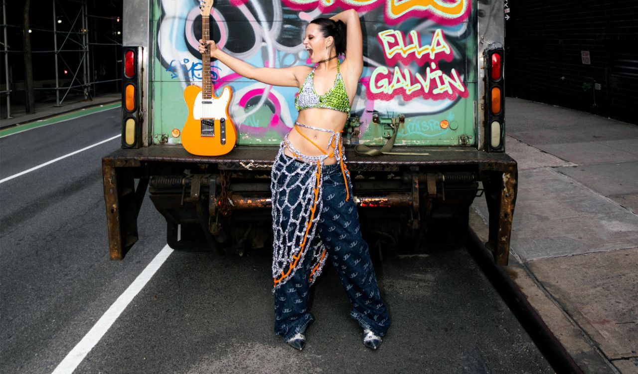 female singer standing behind a box truck