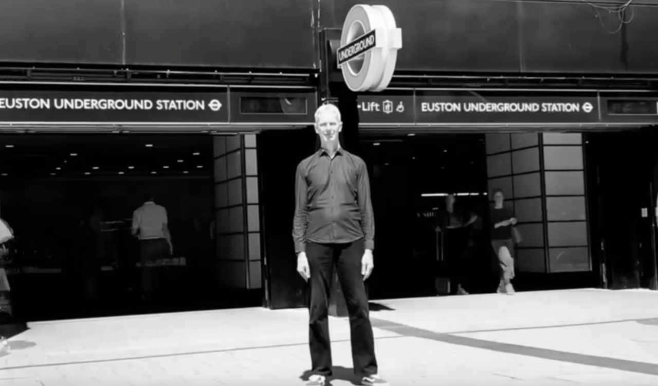 man standing in front of a train station