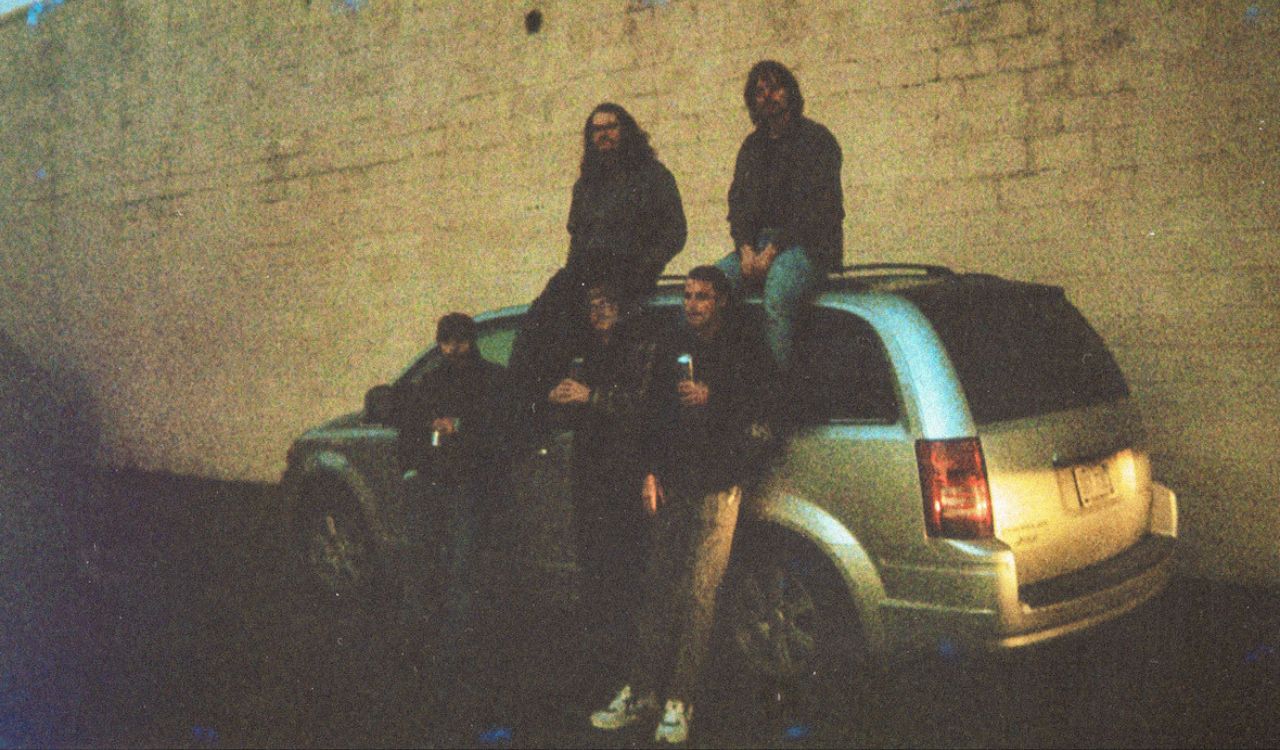 band leaning against a car
