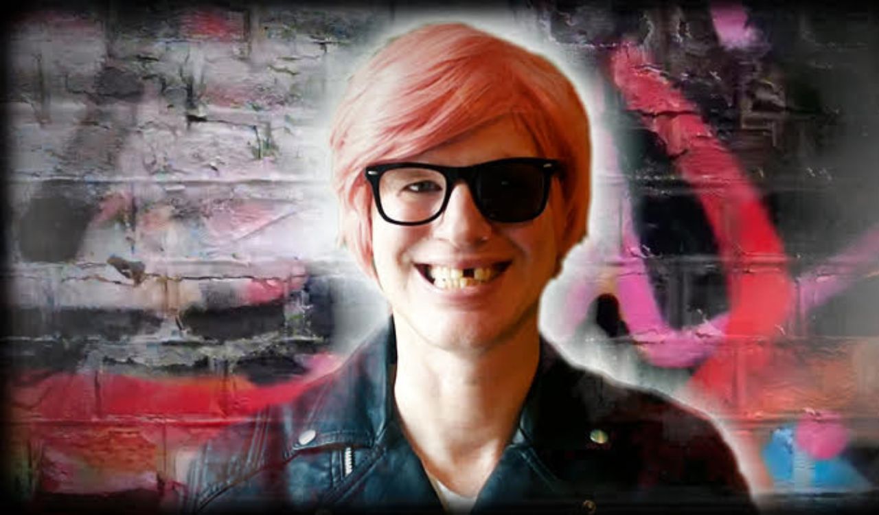 male singer with pink hair and glasses