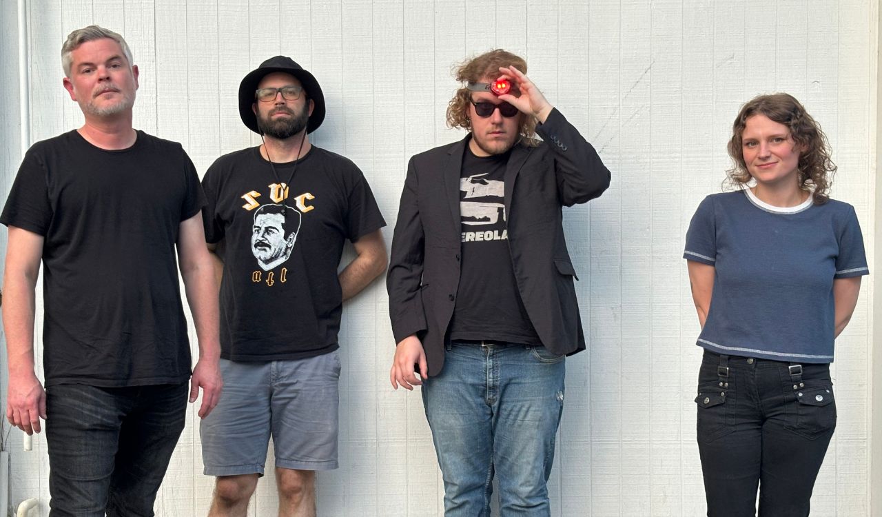 band standing in front of a white wall