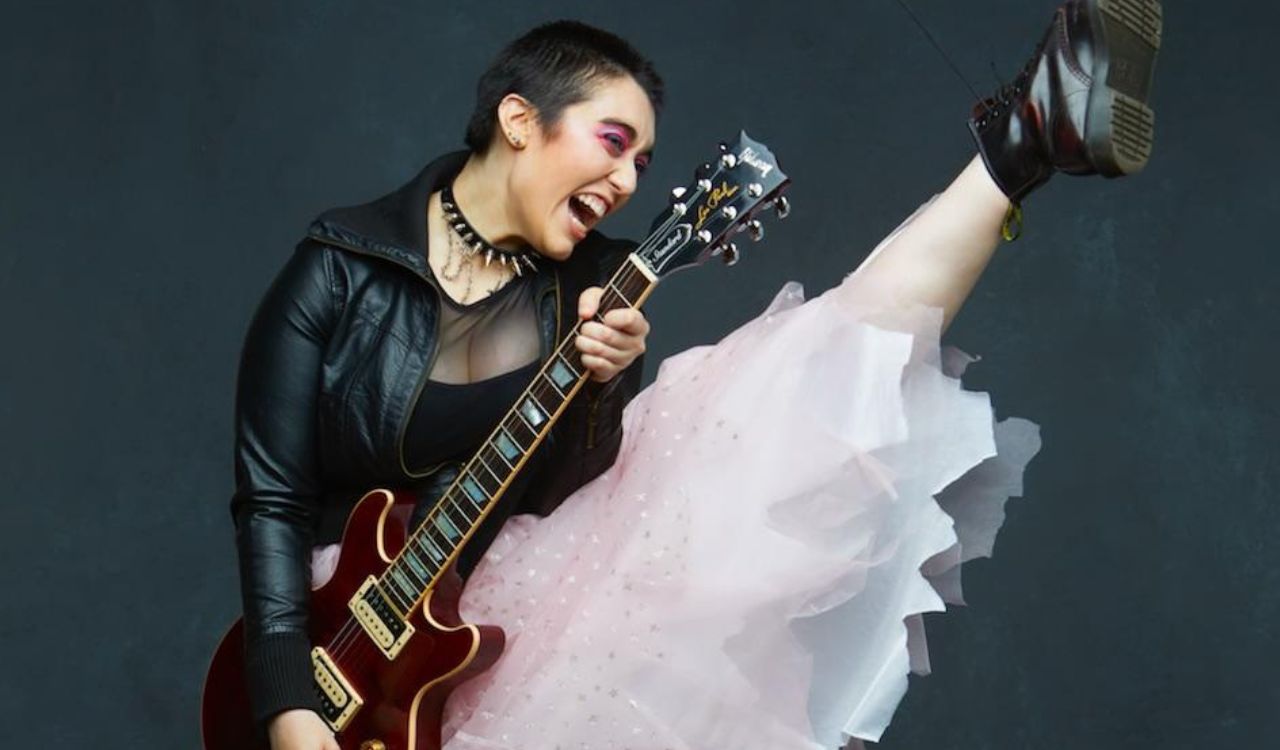 musician in a pink skirt playing guitar