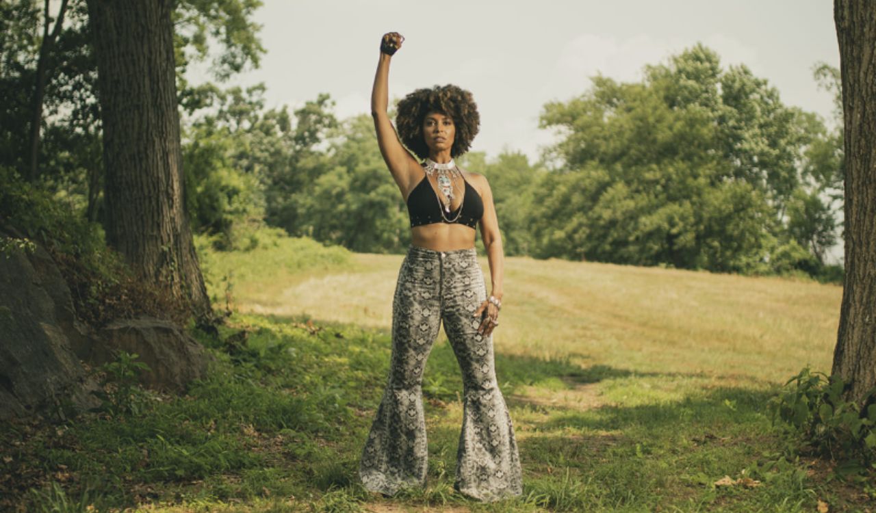 woman standing outside in grass between trees