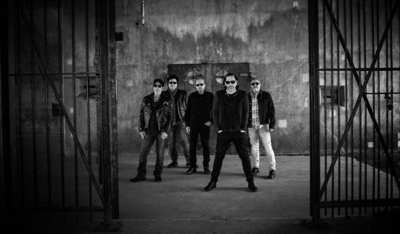 band standing in an empty concrete room