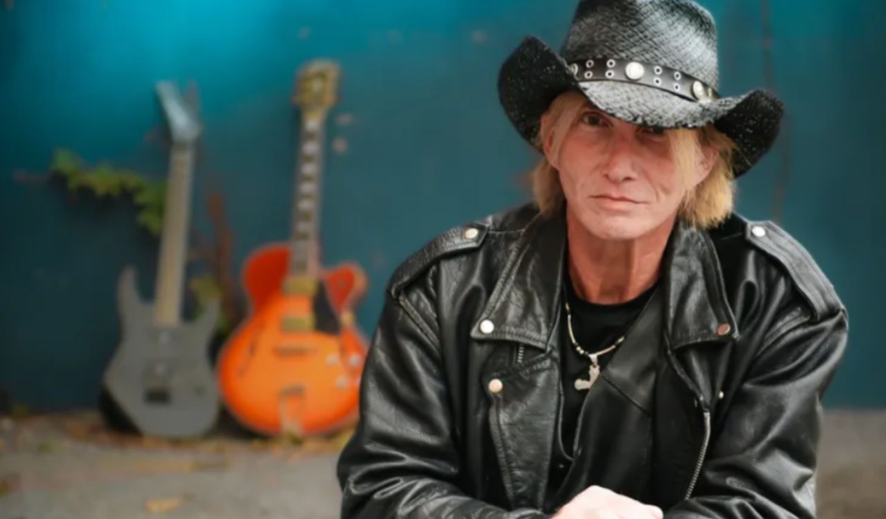 musician kneeling in front if his guitars