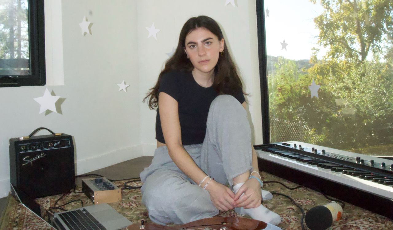 woman sitting on the floor with a guitar