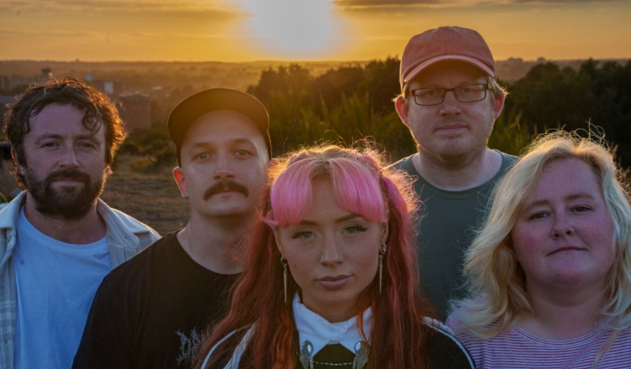 band standing outside at sunset