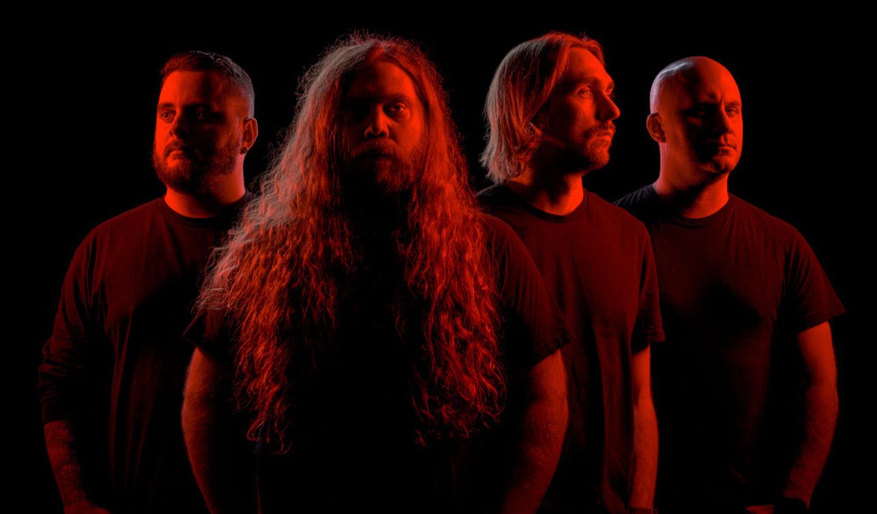 metal band standing under a red spotlight