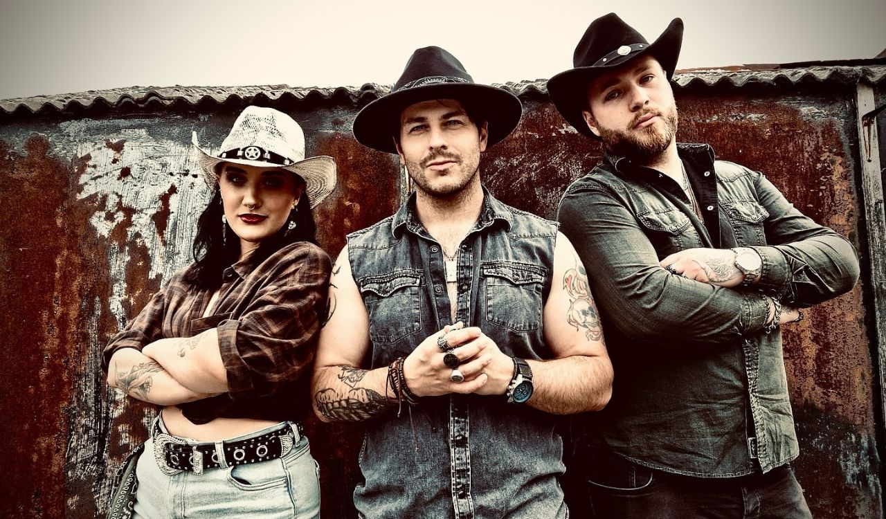 hard rock band standing outside wearing cowboy hats