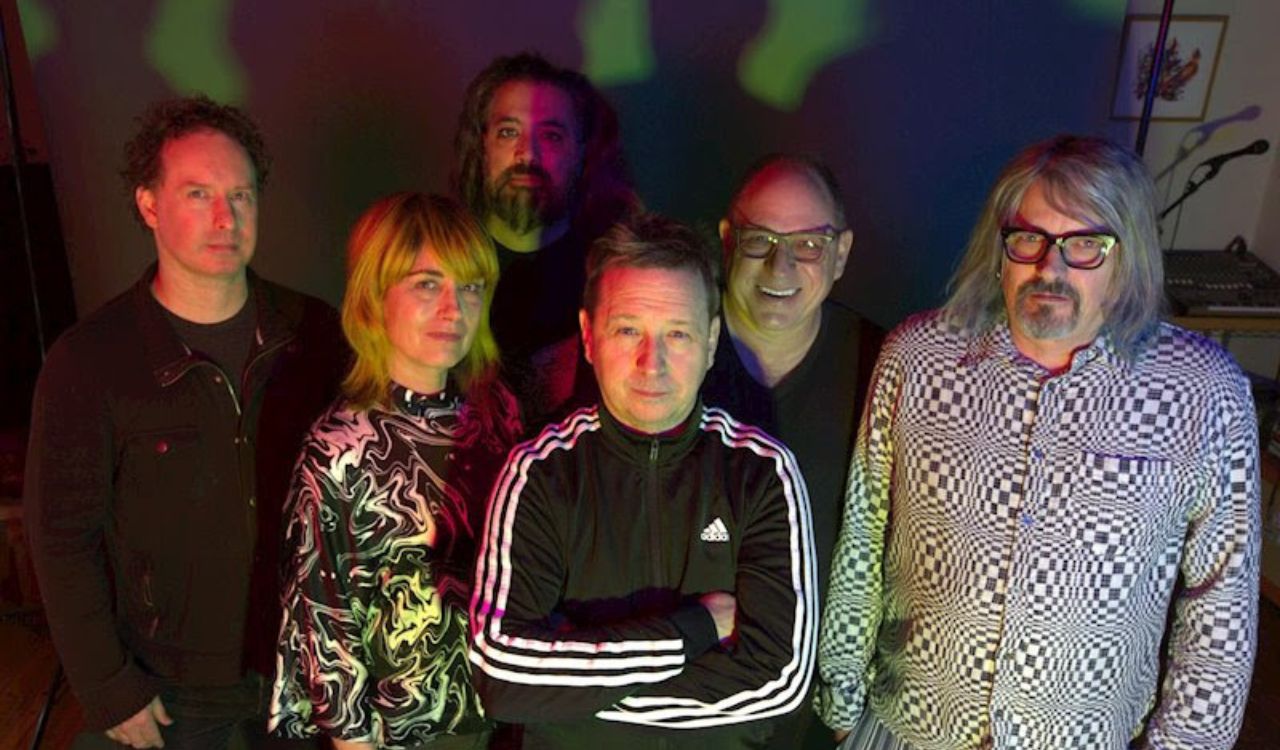 band standing in front of a psychedelic background