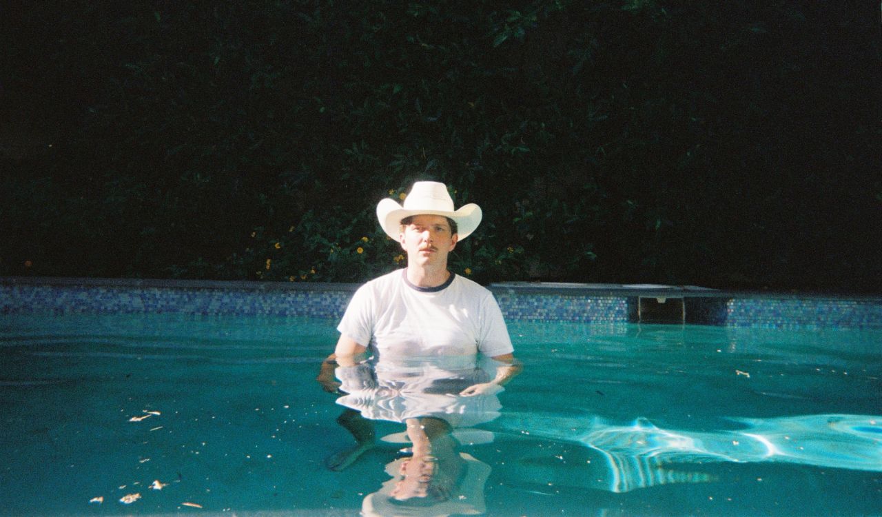 male singer standing in a swimming pool