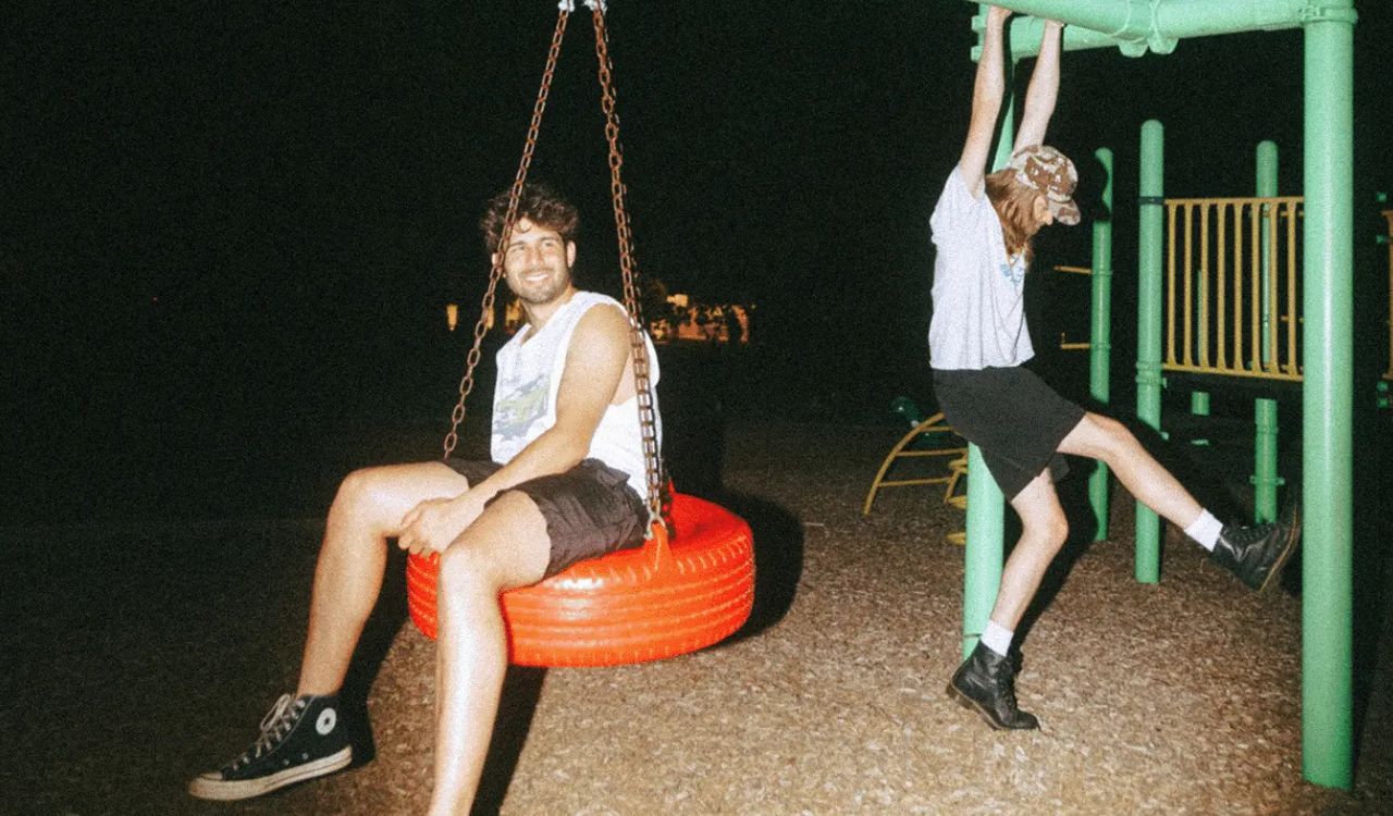 two adults playing on a playground at night