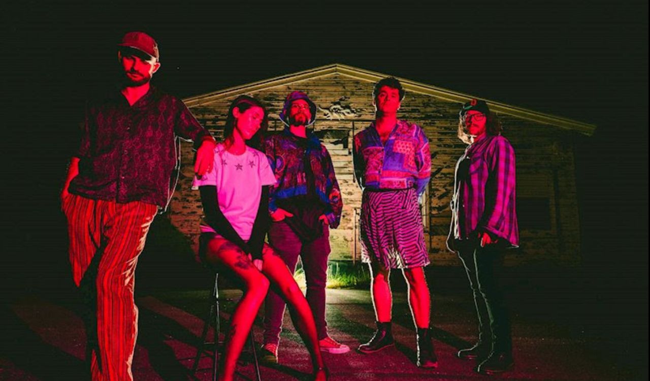 band in front of an old stone building at night